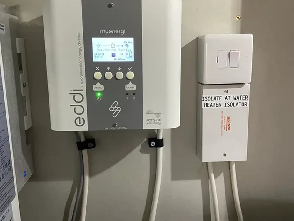 myenergi Eddi solar diverter installed on a wall beside its isolator