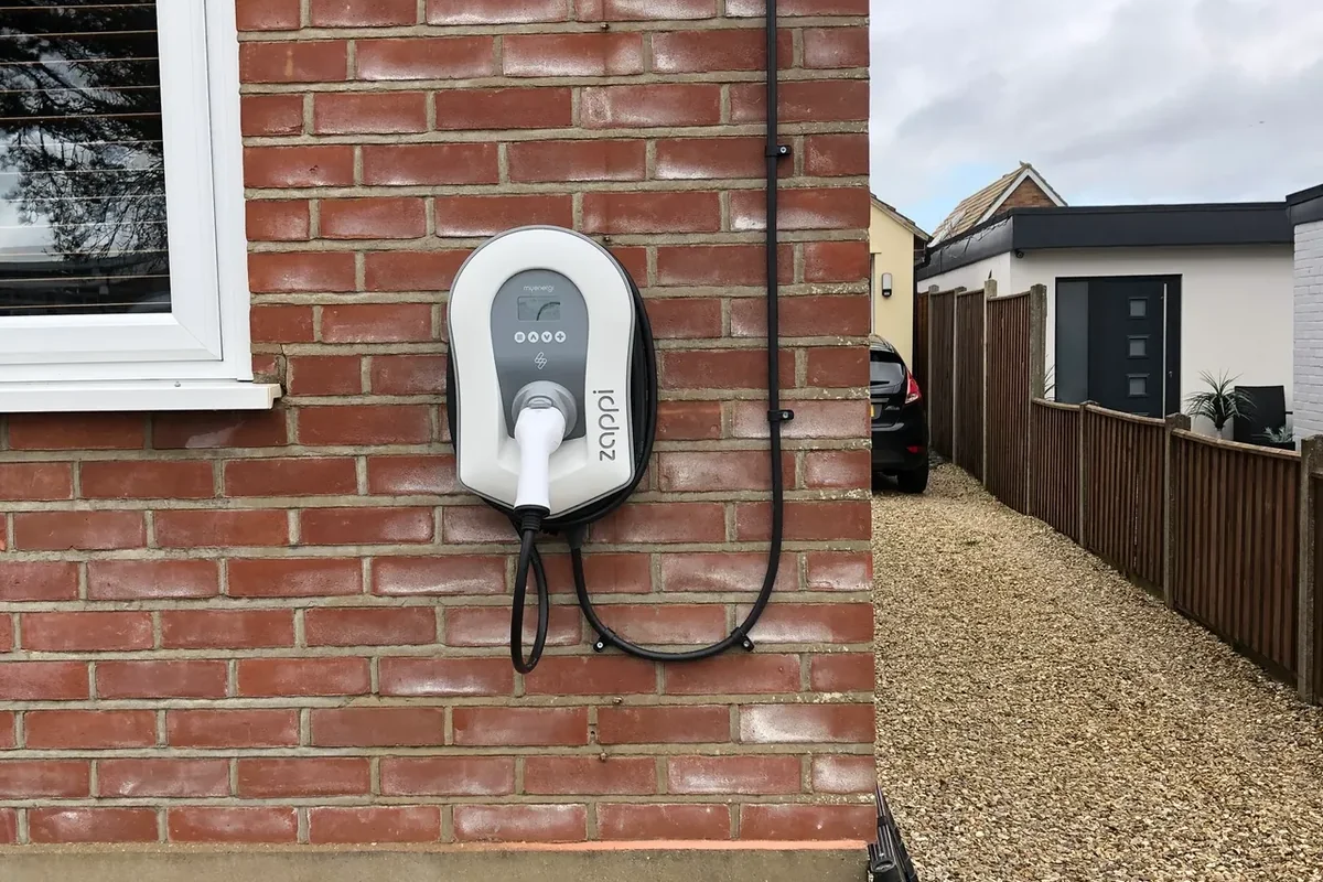 Zappi EV charger wall-mounted with a tidy cable run to the drive